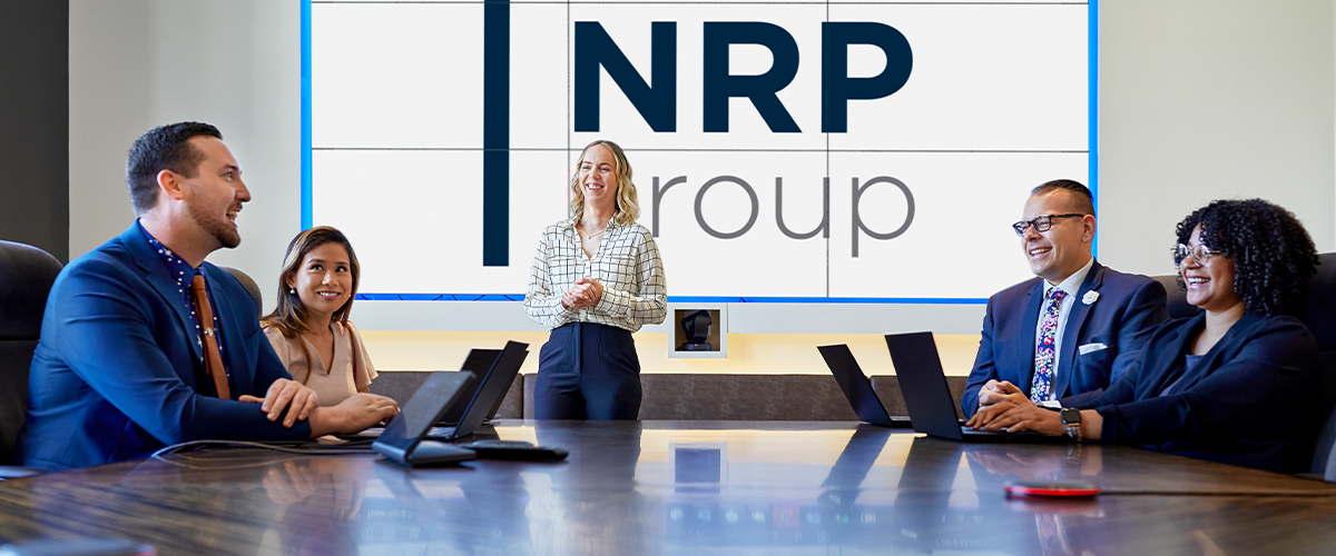 NRP Group meeting taking place in conference room with one standing speaker