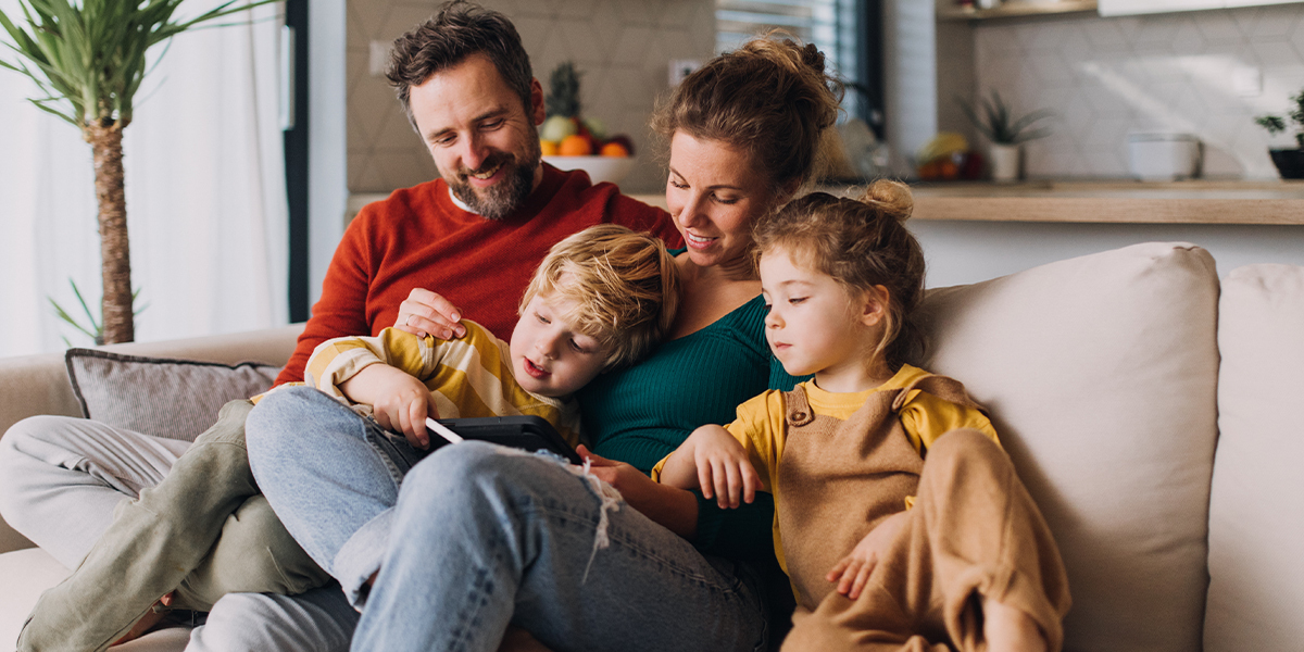 Young family sitting together on a couch.