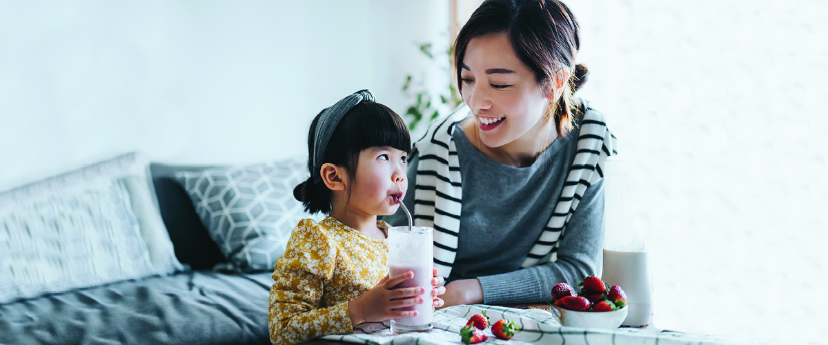 A woman and small child enjoying a smoothie.