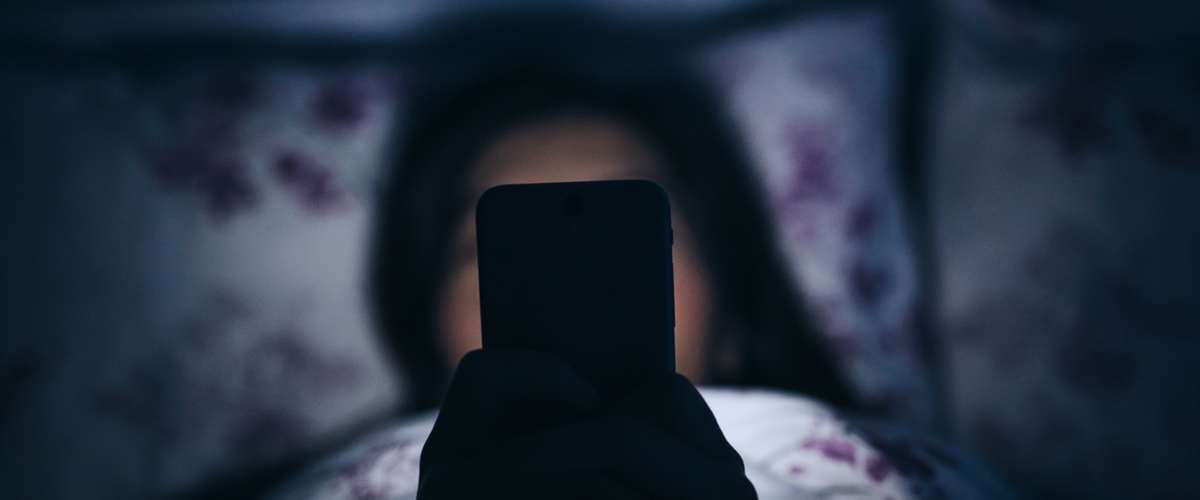 Woman using her cell phone in the dark.