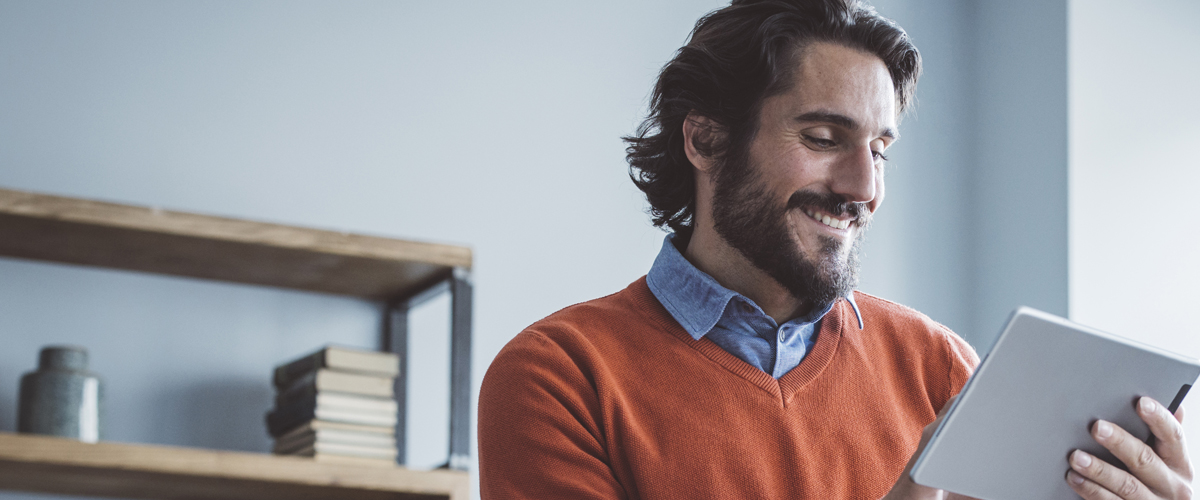 Person smiling and using a tablet.