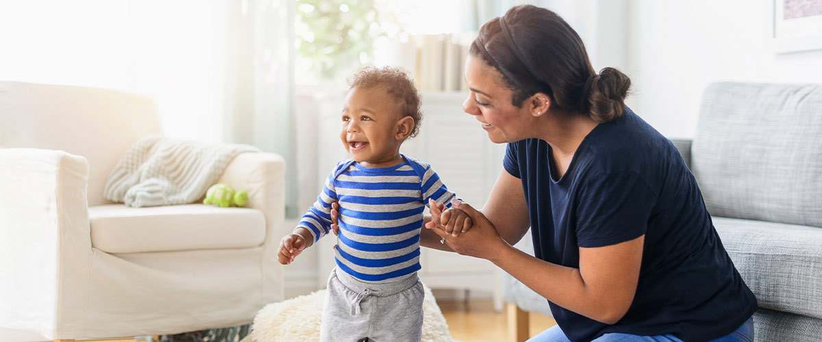 A mom helping a baby stand.