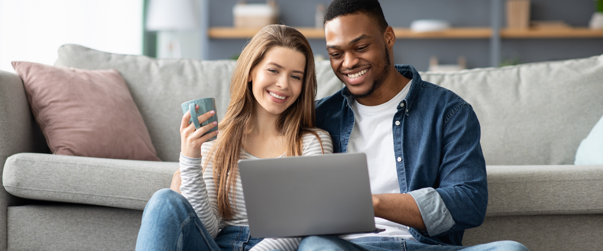 Young couple sitting together looking at a laptop.
