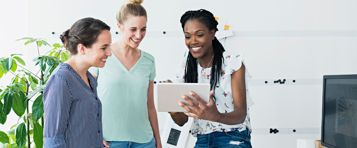 Coworkers looking at a tablet together.