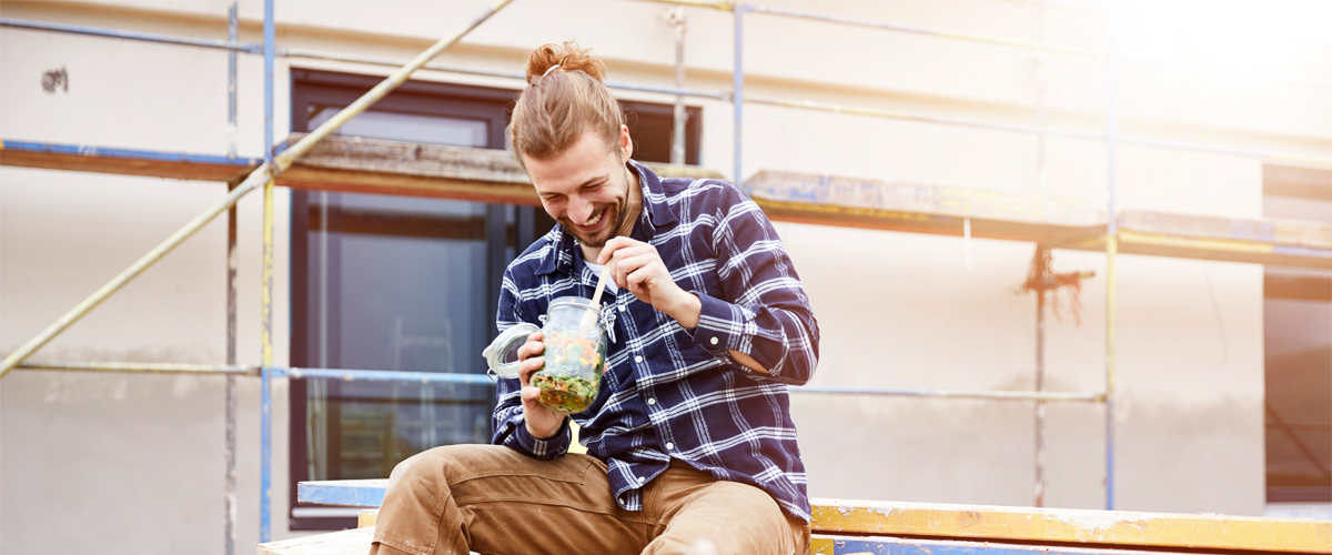A construction worker eating lunch at a worksite.