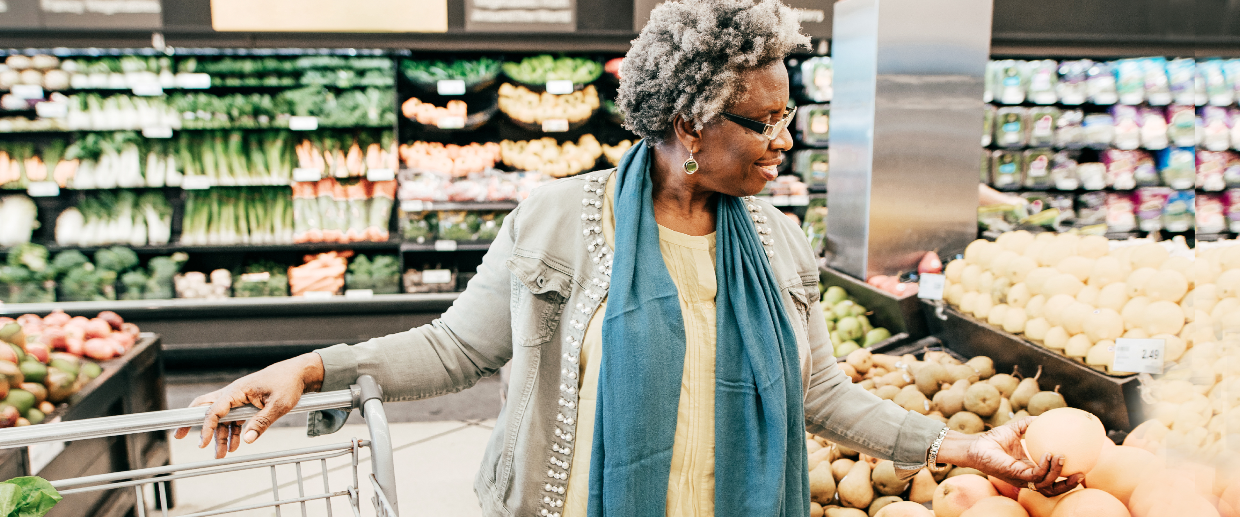 Woman shopping in the produce section of a grocery store.