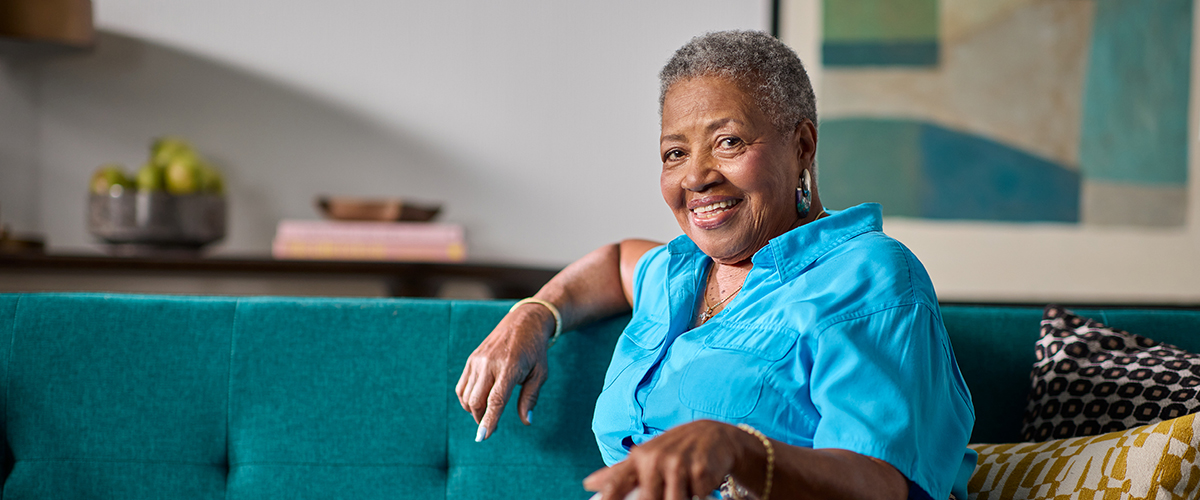 Senior woman sitting on a couch at home.