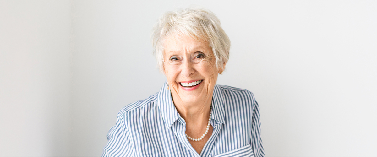 older woman smiling with white background