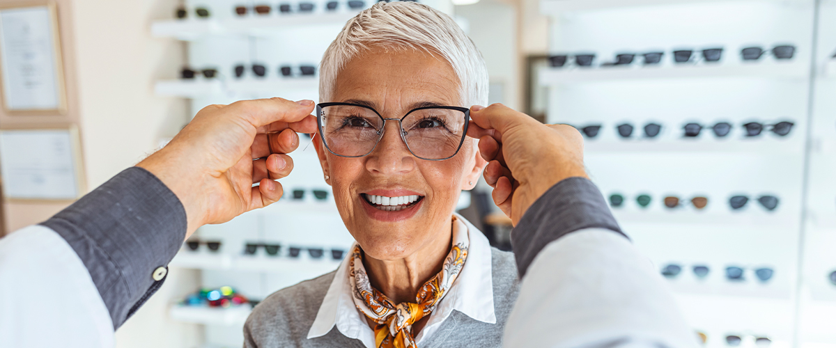 Senior woman trying on glasses.