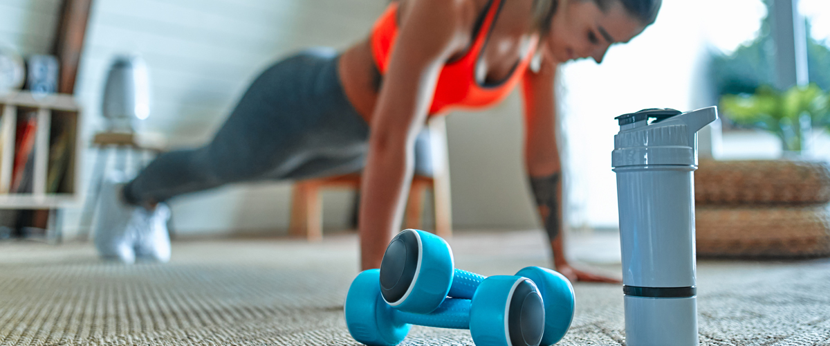Woman working out by doing push-ups at home.