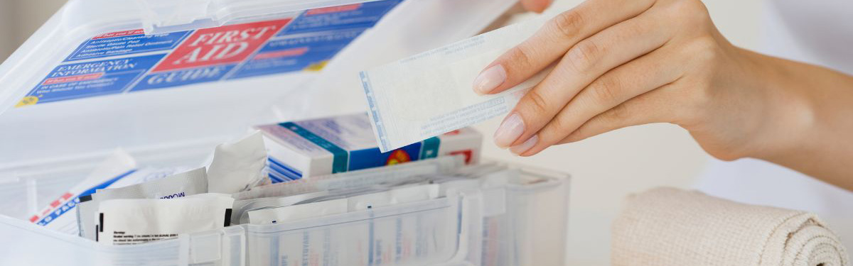 Hands pulling a bandage out of a first aid kit.