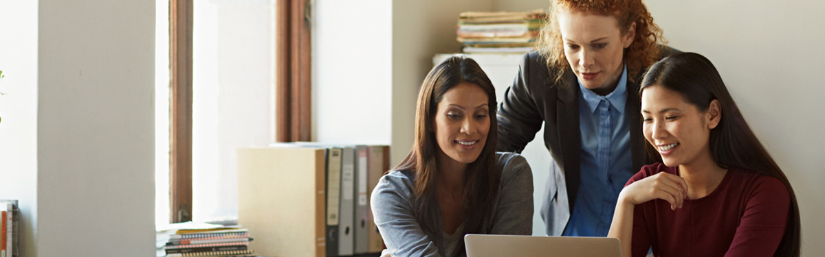Group of colleagues looking at a laptop.