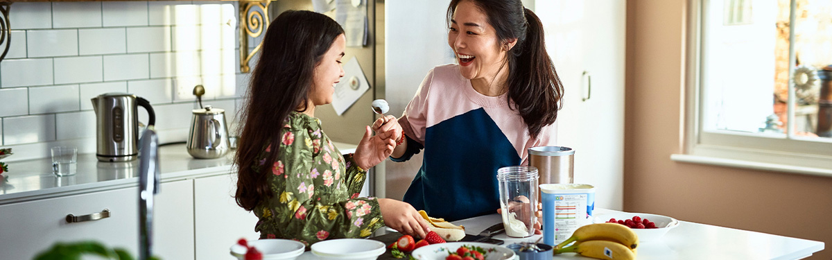 Woman cutting up fruit with her daughter.