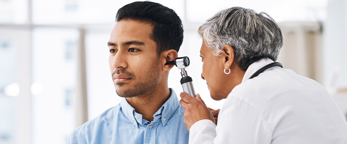 Ear examination being conducted by a healthcare professional in a modern clinical environment.