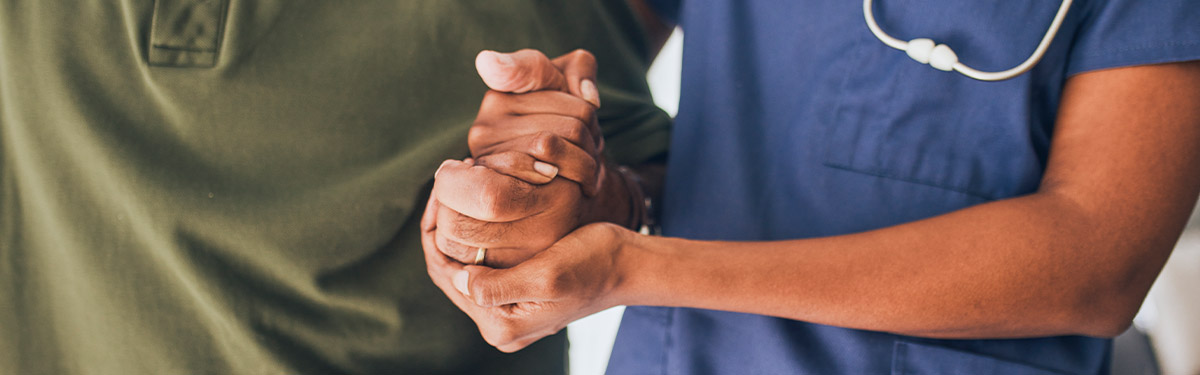 nurse holding mans hand
